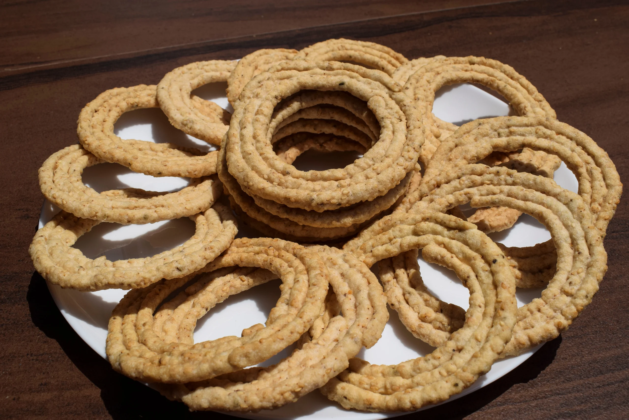 A plate of crispy Sakinalu, a traditional Telugu snack made with rice flour and savory spices.