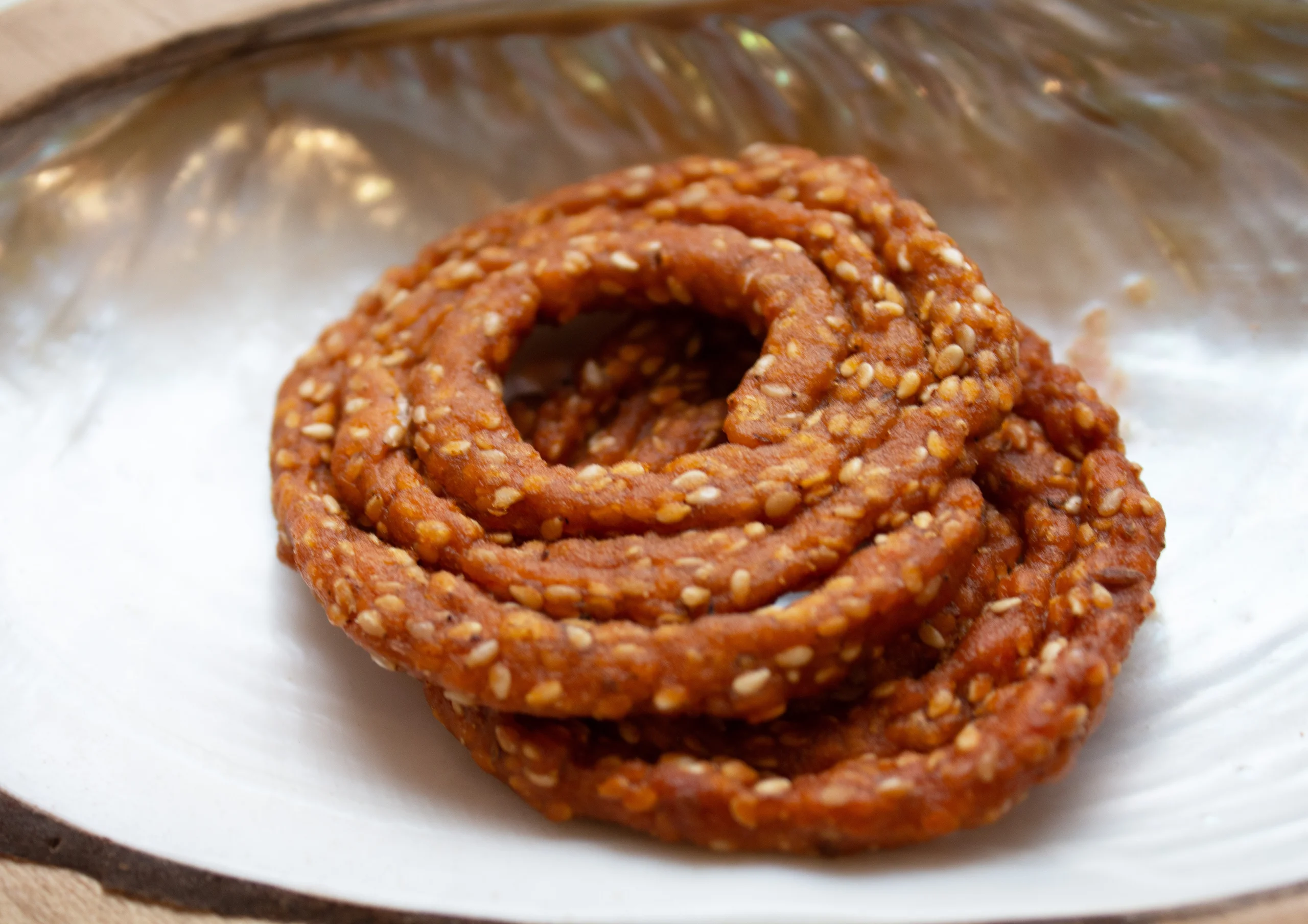 A plate of crispy and spicy Telangana Sakinalu, a traditional Telugu snack made with rice flour and sesame seeds.