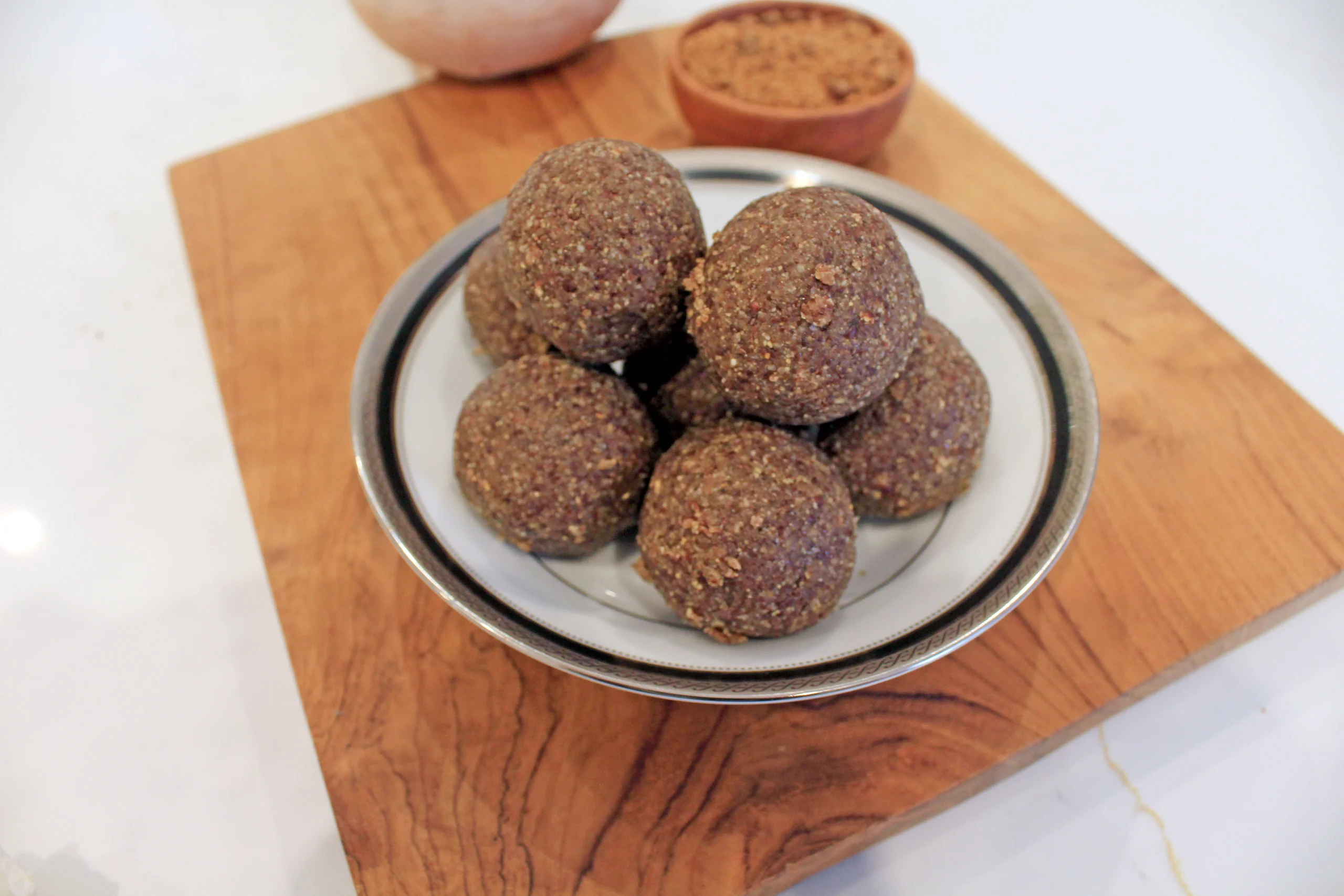 Alt Text: A close-up of healthy Flaxseed Ladoo, an Indian sweet made from roasted flaxseeds, jaggery, and ghee, showcasing its round shape and wholesome ingredients.