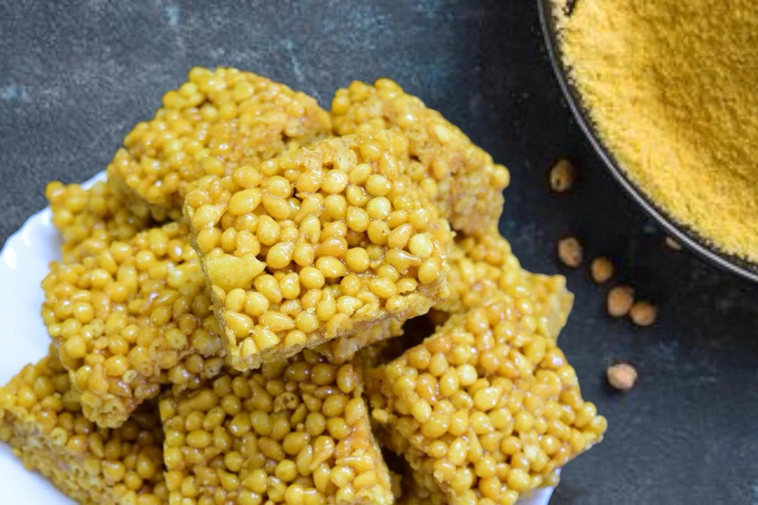 A close-up of Boondi Chikki by Reddot Food, showing the crunchy boondi pieces bound together with jaggery, highlighting the sweet and crunchy texture of this traditional Indian snack.