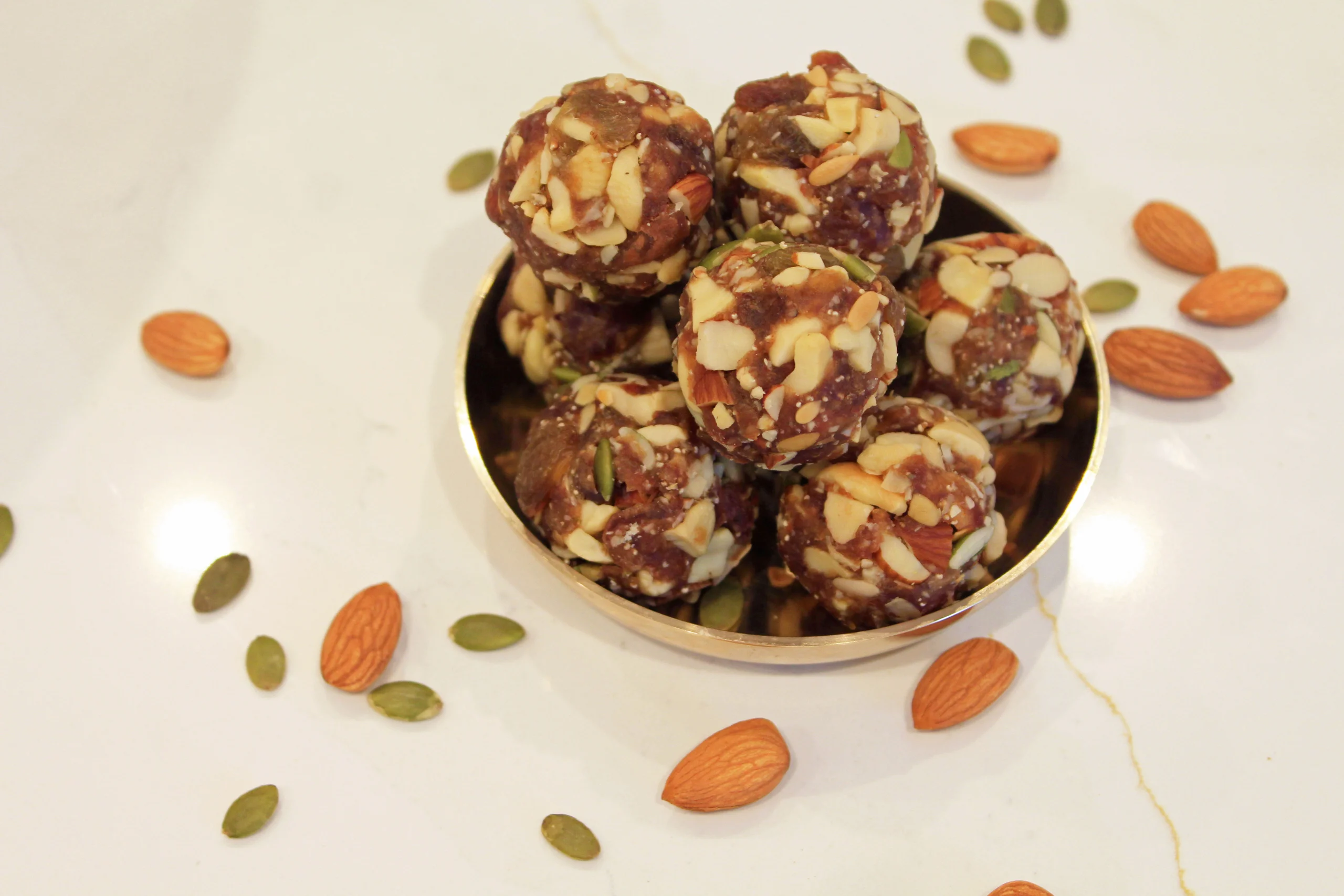 A close-up of Dry Fruit Ladoo by Reddot Food, showing the rich texture and assorted nuts and dried fruits within the ladoo, emphasizing its nutritious and indulgent nature.