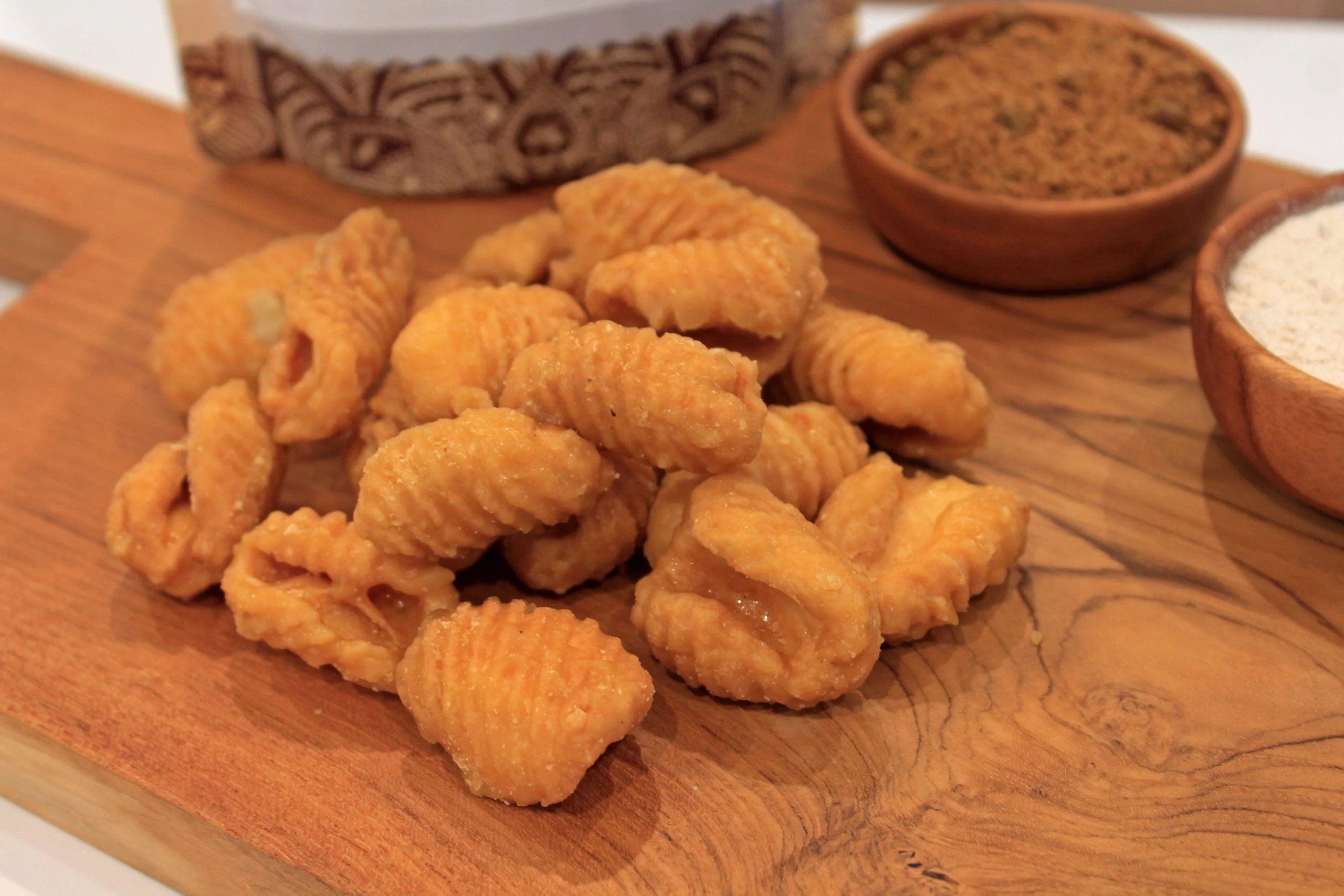 A close-up of Sweet Gavvalu, a traditional South Indian sweet by Reddot Food, showcasing its conical shape and rich, golden-brown color, coated with jaggery syrup.