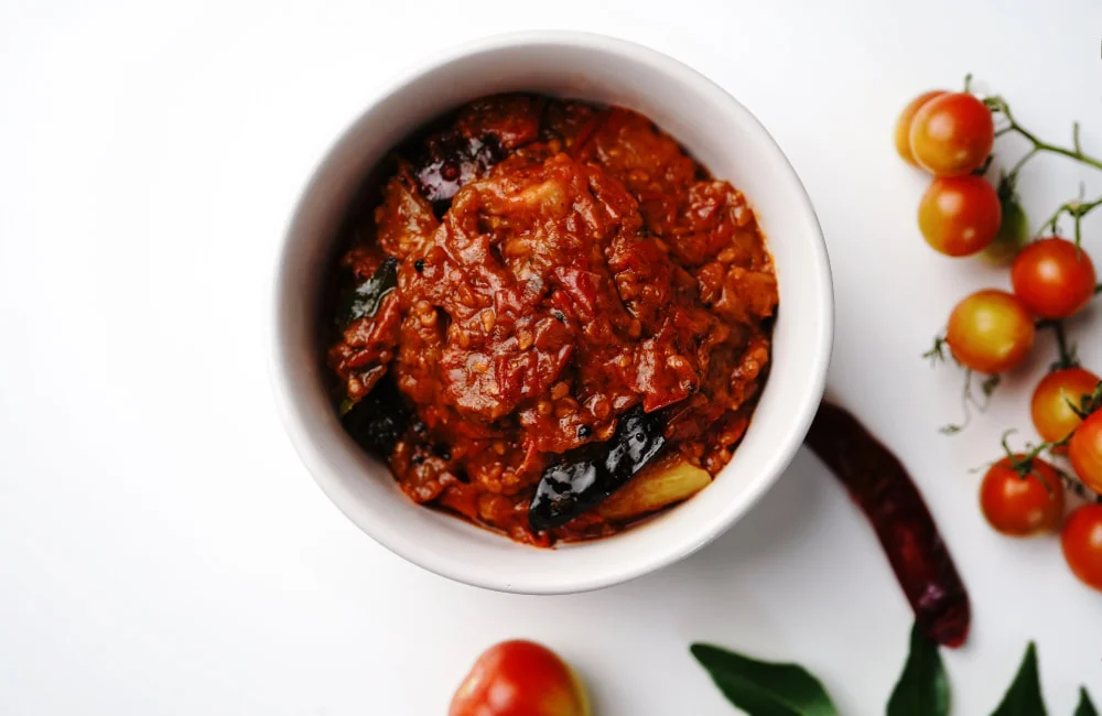 A close-up of Tomato Pickle from Reddot Food, showcasing its vibrant color and rich texture, made from ripe tomatoes and aromatic spices.