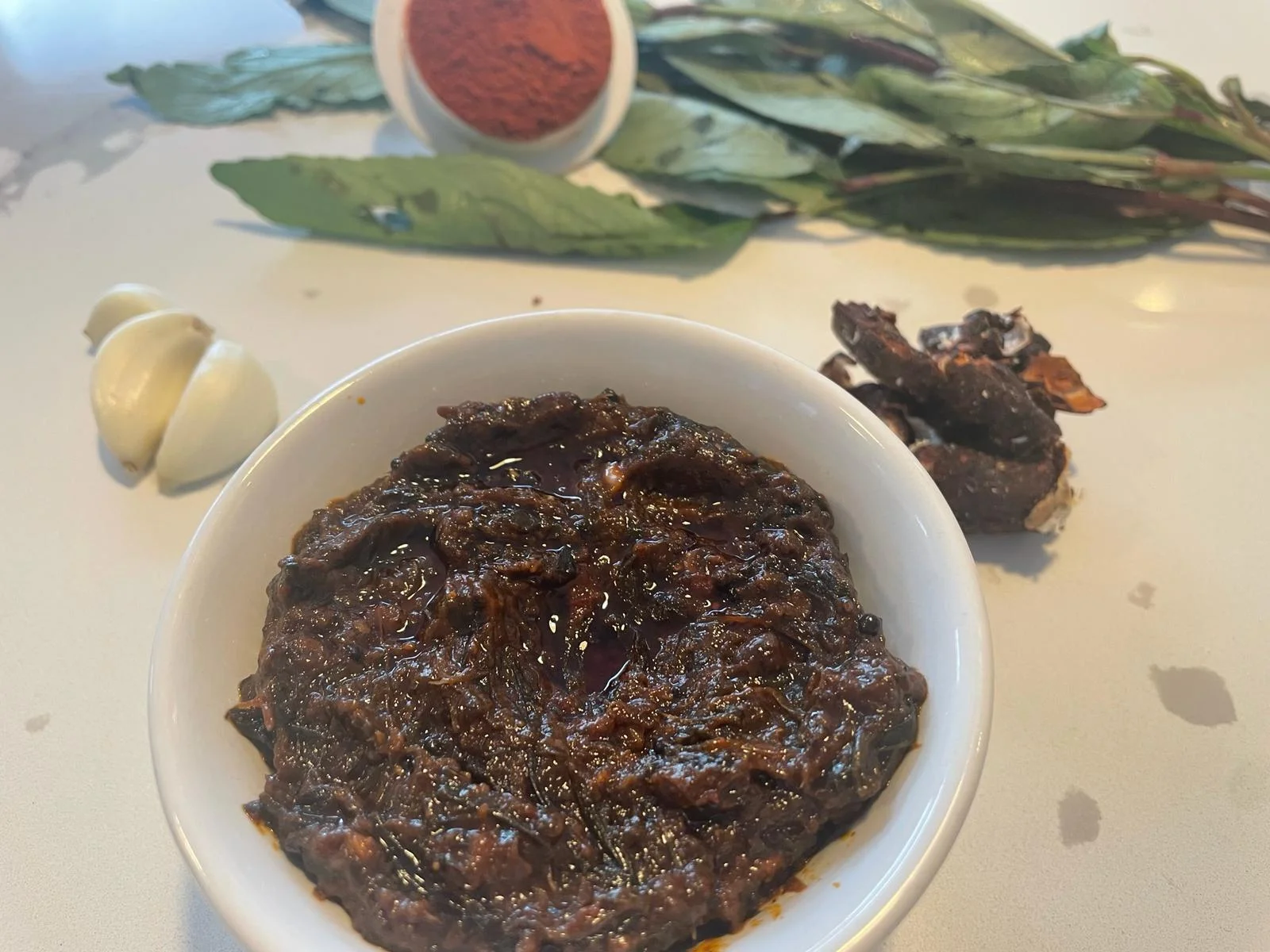 A bowl of Gongura Pickle from Reddot Food, featuring rich, red sorrel leaves in a flavorful, spicy blend.