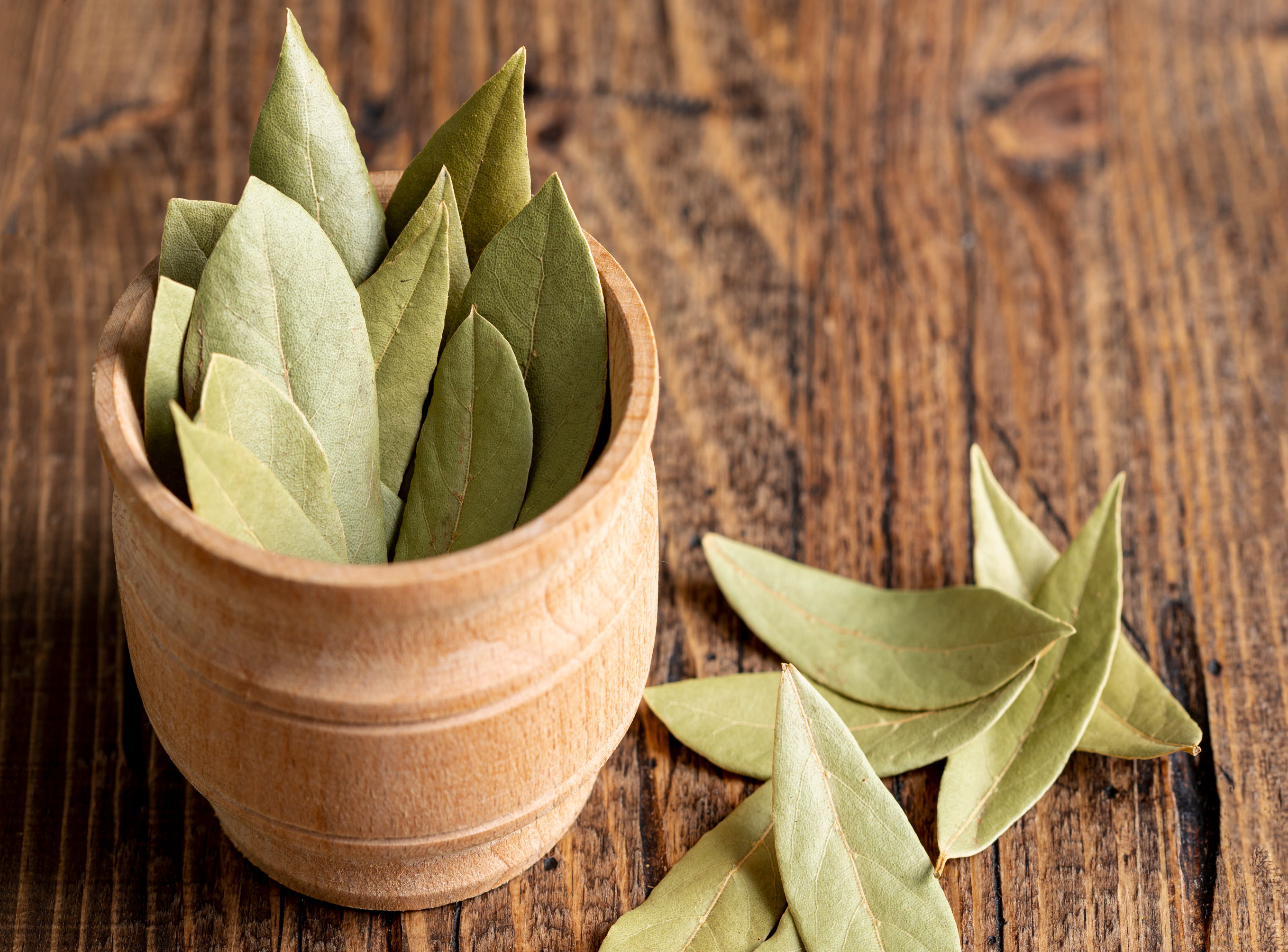 Close-up of dried Bay Leaves, showcasing their green texture and aromatic quality.